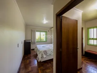 Quarto com piso de madeira e janela em uma residência.