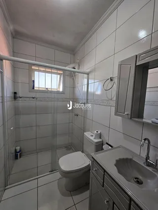 Foto de um banheiro com piso e paredes revestidos de cerâmica.