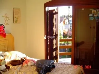 Quarto interno com paredes de cor neutra e piso de madeira.