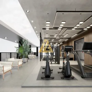 Uma foto de uma área de ginástica interna com esteiras de corrida e equipamentos de treino.