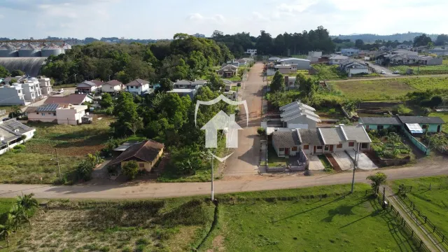 Vista aérea de uma propriedade rural com casas e campos ao redor.