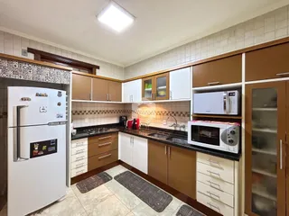 Foto de uma cozinha com armários de madeira e revestimento cerâmico.