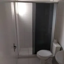 Foto de um banheiro com revestimento cerâmico e vaso sanitário branco.