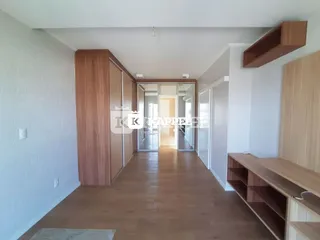 Hall de entrada com piso de madeira e armários em uma residência.