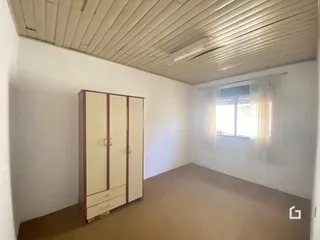 Quarto com armário e teto de ripas na residência.