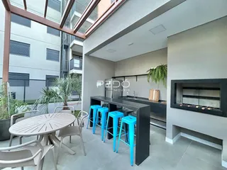 Imagem de uma área de estar com mesa de jantar e cozinha em um imóvel no Brasil.