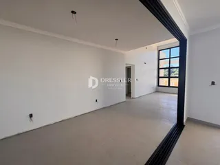 Espaço interno amplo com paredes brancas e piso claro.