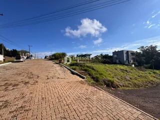 Vista da rua pavimentada em Lajeado, Brasil, com casas ao fundo.