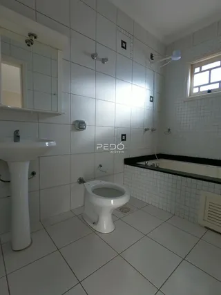 Foto de um banheiro com revestimento cerâmico branco.