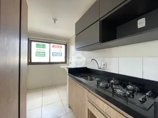 Vista da cozinha com armários e bancada escura.