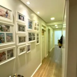 Foto de um corredor interno bem iluminado com piso de madeira.