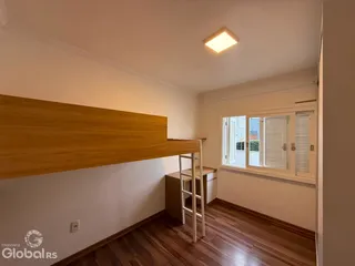 Interior de uma sala com piso de madeira e armários de madeira.