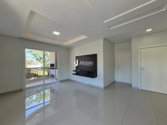 Sala de estar ampla com piso de cerâmica e portas de vidro.