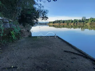 Vista de um rio calmo com vegetação nas margens.
