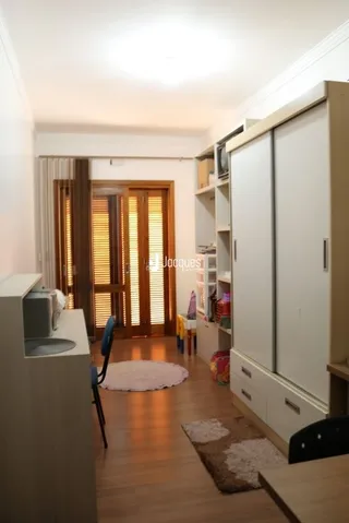 Quarto interno com armários embutidos e piso de madeira.