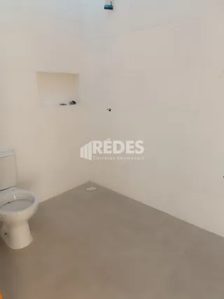 Foto de um ambiente interno com piso de concreto e vaso sanitário.