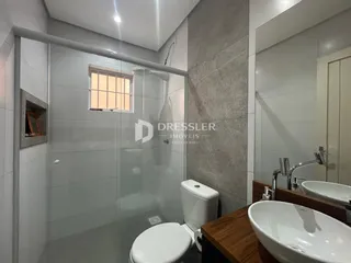 Foto de um banheiro com box de vidro e pia.