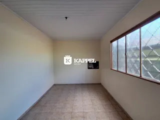 Uma sala de estar com piso de cerâmica e grande janela é visível na propriedade.