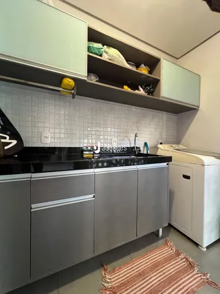 Cozinha moderna com armários cinzas e revestimento de azulejos brancos.