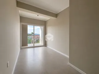 Interior de um corredor com porta de vidro abrindo para uma vista externa.