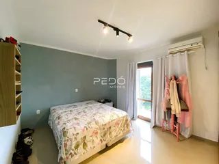 Quarto com cama e janela em ambiente claro.