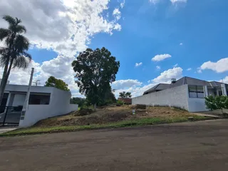 Fachada externa de uma casa branca em Lajeado, Brasil, com terreno gramado em primeiro plano.