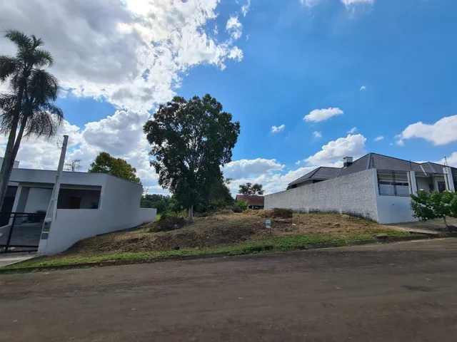 Fachada externa de uma casa branca em Lajeado, Brasil, com terreno gramado em primeiro plano.