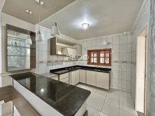 Foto de uma cozinha com armários brancos e piso cerâmico.