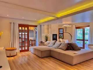 Sala de estar ampla com piso de madeira e portas de vidro.