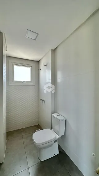 Foto de um banheiro interno com revestimento cerâmico nas paredes.