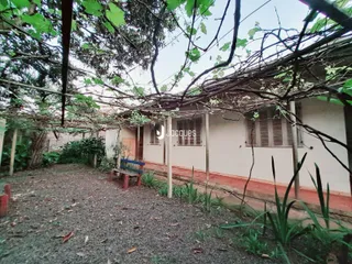 A fachada de uma casa em Lajeado, Brasil, é vista através de vegetação densa.