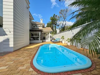 Foto da área externa com piscina e jardim de uma residência em Lajeado.