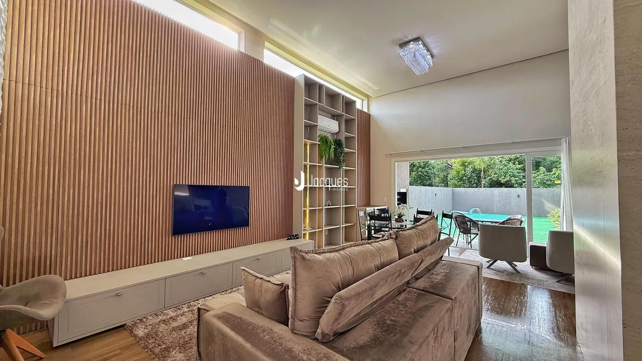 Sala de estar com sofá e televisão em um ambiente moderno.
