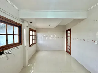 Corredor com janelas de madeira e paredes brancas.
