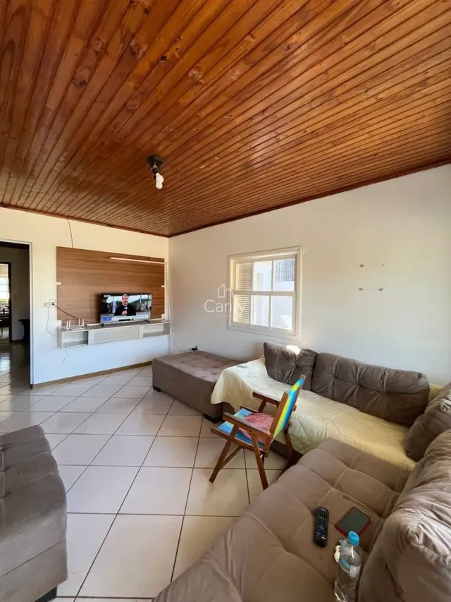 Sala de estar com sofá e piso de cerâmica em um imóvel.