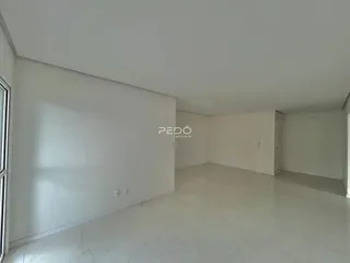 Ambiente interno de uma sala ampla e clara.