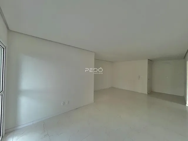 Ambiente interno de uma sala ampla e clara.