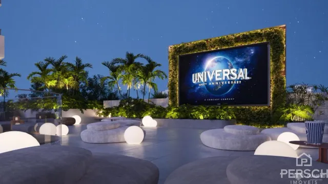 Vista noturna de um jardim moderno com bancos arredondados e um letreiro iluminado.