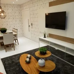 Sala de estar moderna com televisão montada na parede.