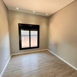 Sala de estar com piso de madeira e janela.