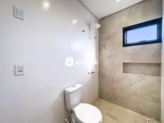 Banheiro com paredes brancas e piso claro.