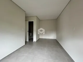 Hall de entrada com piso de cerâmica e paredes brancas.