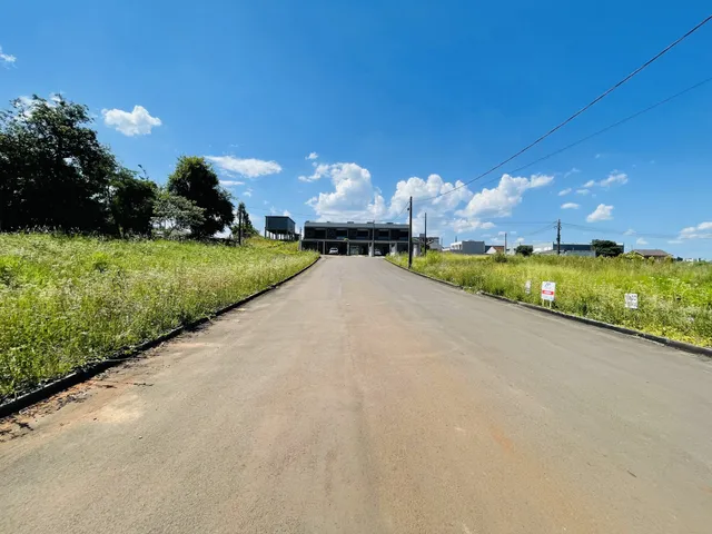 Uma estrada asfaltada leva a um prédio cercado por vegetação.