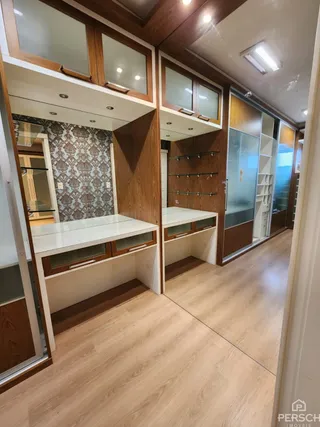 Interior de um ambiente com piso de madeira e armários embutidos.