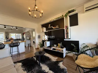 Sala de estar com piso de madeira e decoração moderna em Lajeado.