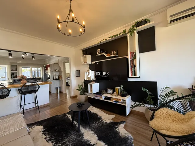Sala de estar com piso de madeira e decoração moderna em Lajeado.