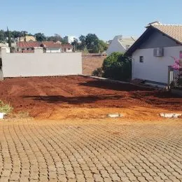 Vista externa de uma residência com terreno em primeiro plano.