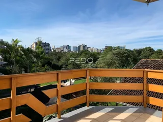 Vista de uma varanda de madeira com vista para a paisagem e a cidade.