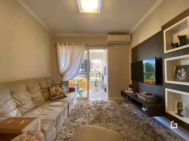 Foto da sala de estar com sofá e parede de madeira.