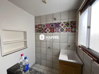 Banheiro com revestimento de azulejos e banheira branca.